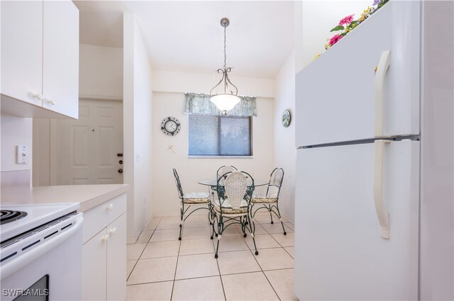 kitchen with white cabinets, light tile patterned flooring, decorative light fixtures, and white appliances