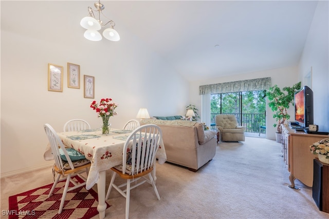 dining area featuring vaulted ceiling, a chandelier, and light colored carpet