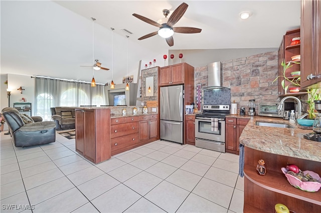 kitchen with ceiling fan, kitchen peninsula, wall chimney range hood, appliances with stainless steel finishes, and light stone countertops