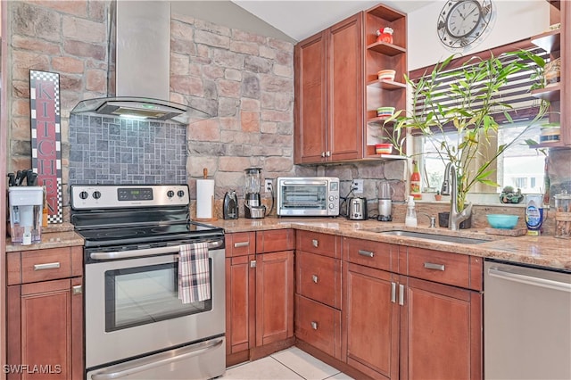 kitchen with light stone counters, backsplash, stainless steel appliances, sink, and wall chimney range hood