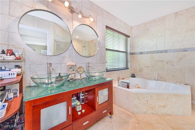 bathroom featuring tile walls, tiled tub, vanity, and tile patterned flooring