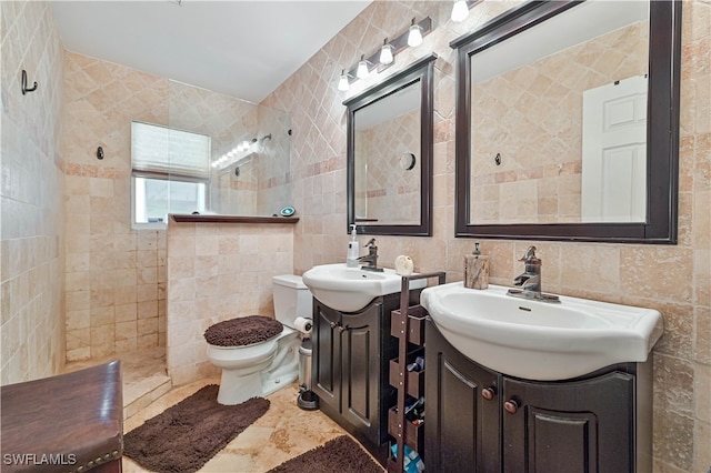 bathroom featuring a tile shower, vanity, tile walls, and toilet