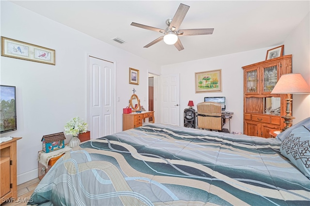 bedroom with hardwood / wood-style flooring, ceiling fan, and a closet