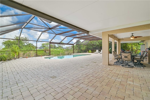 exterior space with glass enclosure, ceiling fan, and a patio area