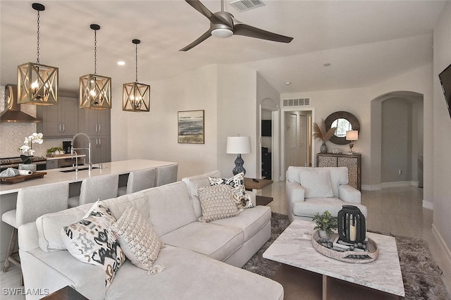 living room with vaulted ceiling, sink, and ceiling fan