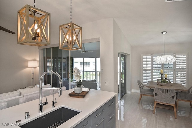 kitchen featuring pendant lighting, lofted ceiling, a healthy amount of sunlight, and sink