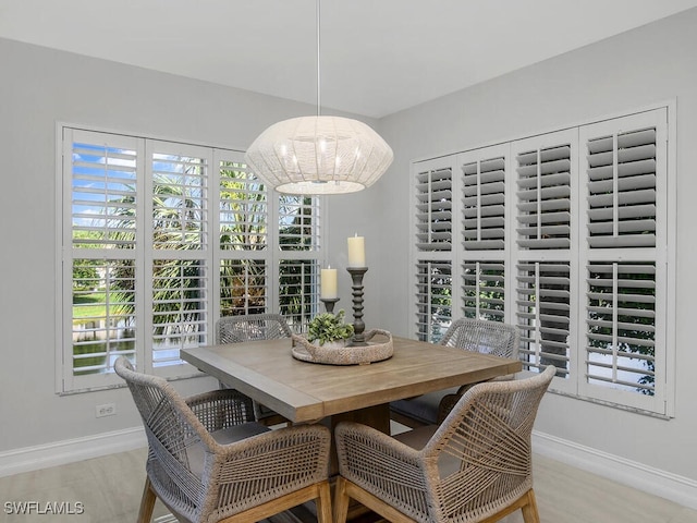 dining space featuring light hardwood / wood-style flooring, a chandelier, and plenty of natural light