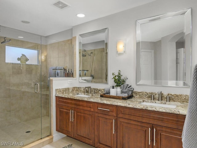 full bath featuring a stall shower, double vanity, a sink, and visible vents