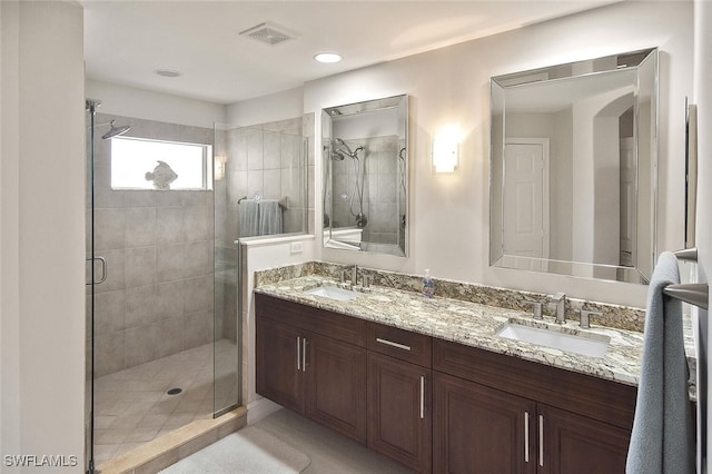 bathroom with a sink, double vanity, visible vents, and a shower stall
