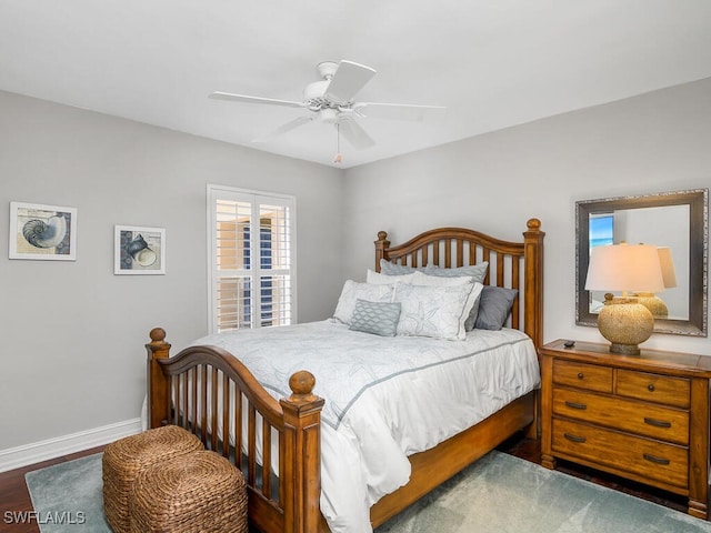bedroom with a ceiling fan, wood finished floors, and baseboards