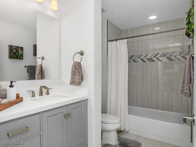 full bathroom featuring shower / bathtub combination with curtain, vanity, and toilet
