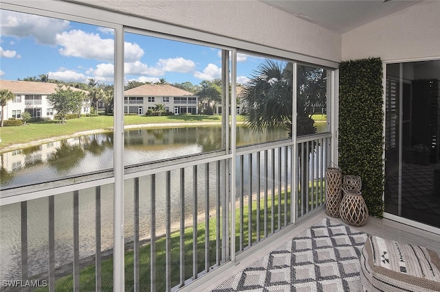 sunroom featuring a water view