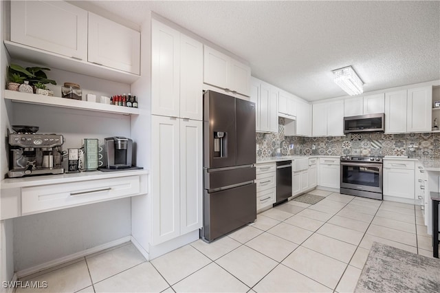 kitchen with white cabinets, backsplash, light tile patterned floors, stainless steel appliances, and a textured ceiling