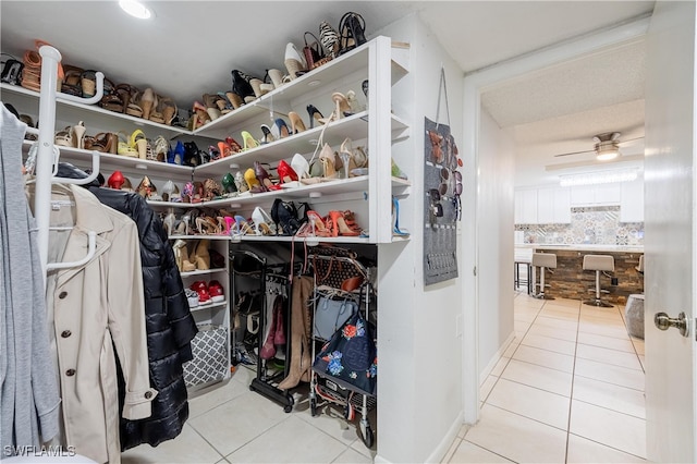 walk in closet with light tile patterned floors and ceiling fan