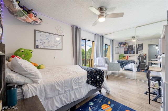 bedroom with light wood-type flooring, a textured ceiling, ceiling fan, and access to exterior