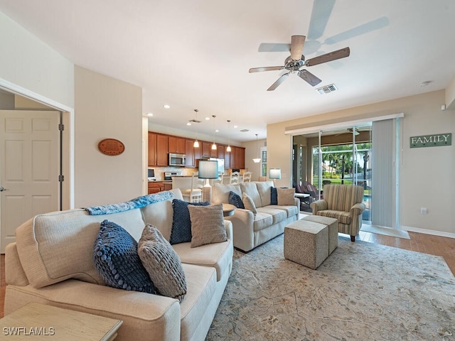 living room featuring light wood-type flooring and ceiling fan