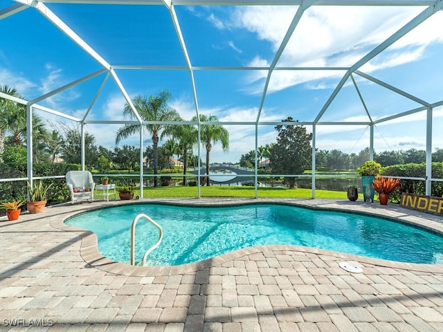 view of pool with a patio, a lawn, and a lanai