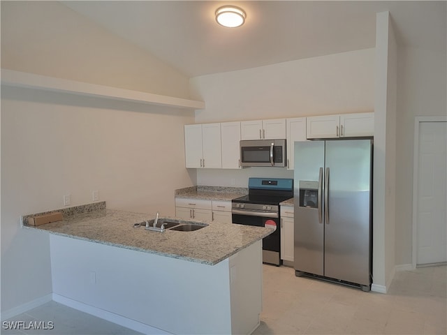 kitchen with appliances with stainless steel finishes, kitchen peninsula, lofted ceiling, and white cabinets