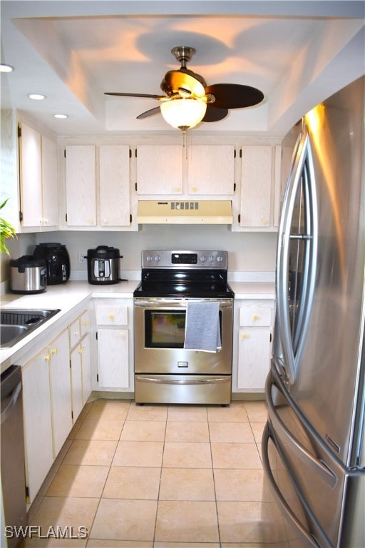 kitchen featuring appliances with stainless steel finishes, a raised ceiling, ceiling fan, and white cabinets