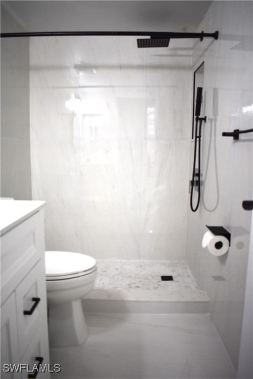 bathroom featuring tiled shower, vanity, and toilet