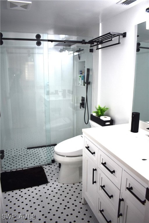 bathroom featuring walk in shower, vanity, and toilet