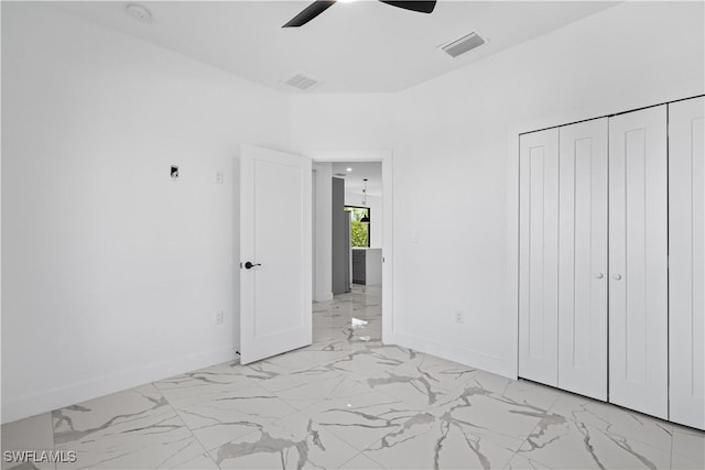 unfurnished bedroom with ceiling fan and a closet