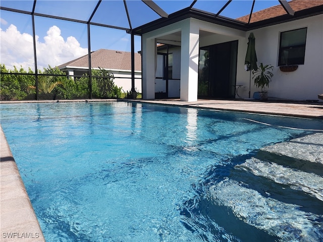 view of swimming pool with glass enclosure and a patio area