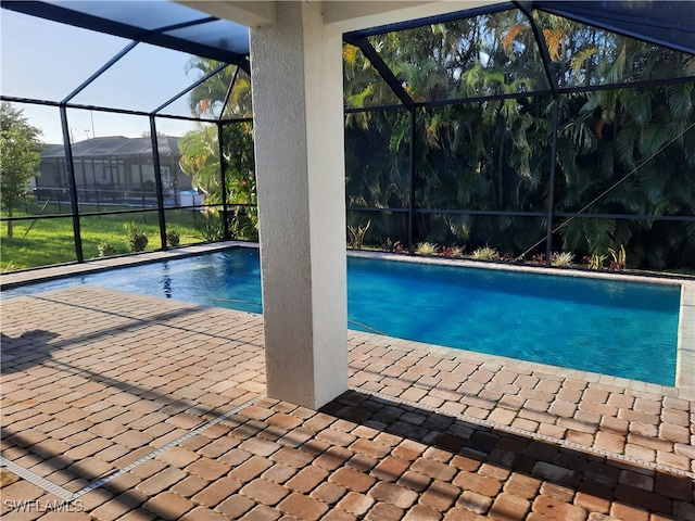 view of swimming pool with glass enclosure and a patio area