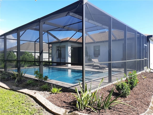 view of swimming pool with glass enclosure and a patio area