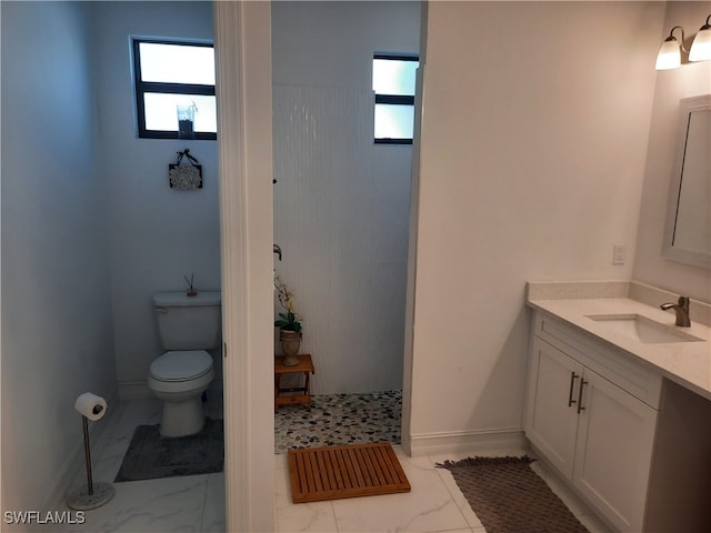 bathroom featuring vanity, plenty of natural light, and toilet