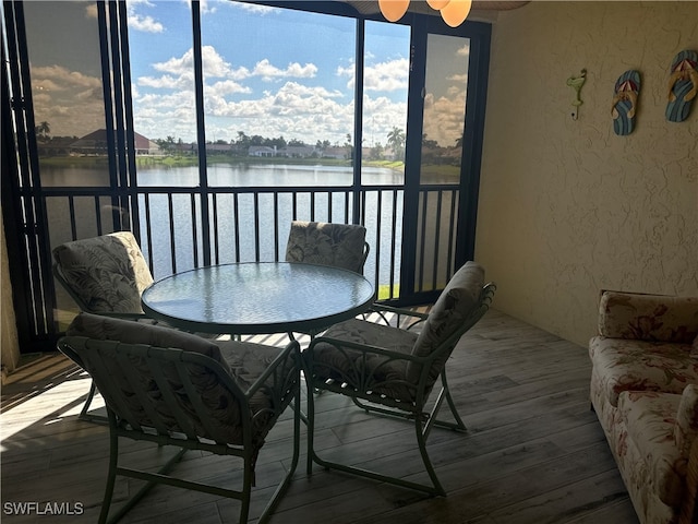 sunroom with a water view and ceiling fan