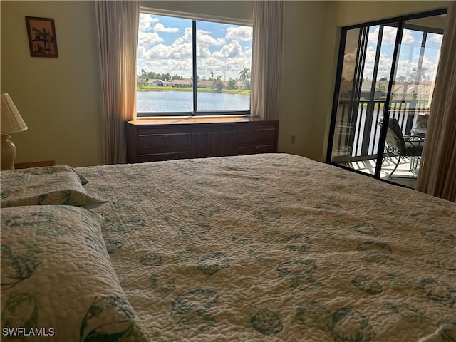 bedroom featuring a water view and access to outside