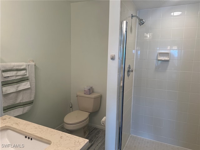 bathroom featuring wood-type flooring, sink, a shower with shower door, and toilet