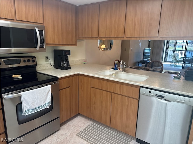 kitchen with light tile patterned flooring, stainless steel appliances, and sink