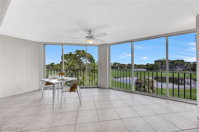 unfurnished sunroom with a water view and ceiling fan