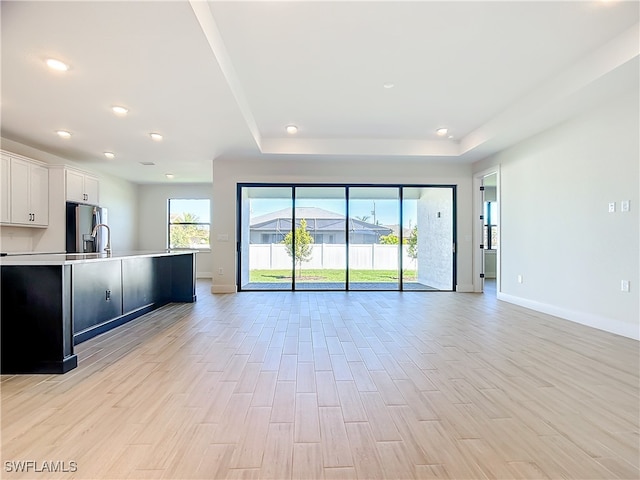 unfurnished living room featuring a tray ceiling