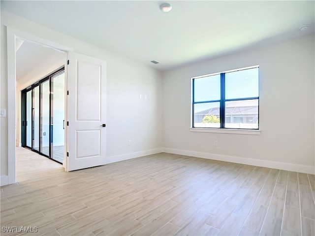 spare room with light hardwood / wood-style flooring