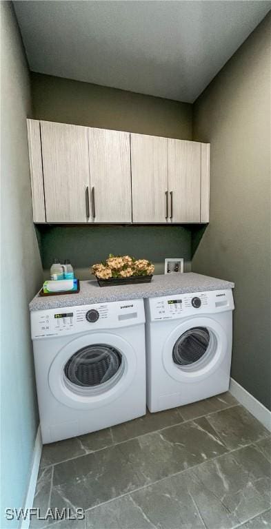 laundry area featuring washing machine and dryer and cabinets