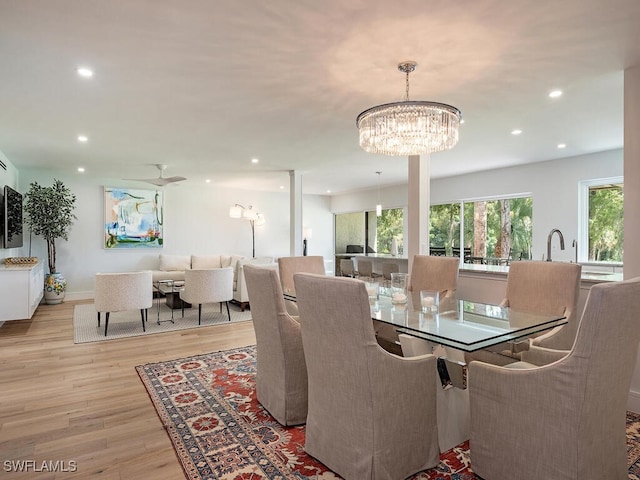 dining space with light hardwood / wood-style flooring and a chandelier