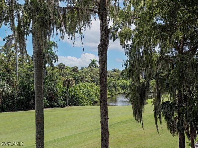 view of home's community featuring a lawn and a water view