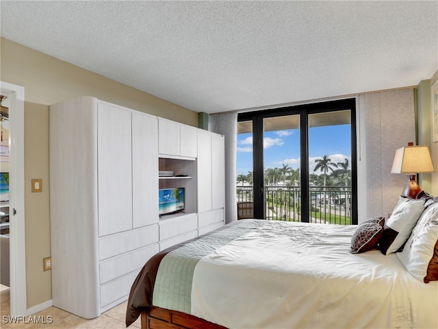 bedroom with floor to ceiling windows, access to exterior, and a textured ceiling