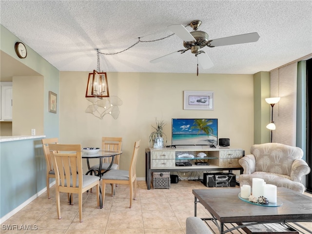 tiled living room with ceiling fan with notable chandelier and a textured ceiling