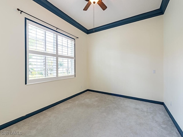 carpeted spare room featuring crown molding and ceiling fan