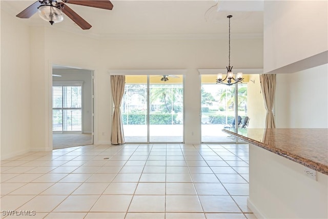 interior space featuring light tile patterned floors, baseboards, crown molding, and ceiling fan with notable chandelier