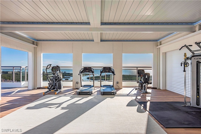 gym with hardwood / wood-style floors, a water view, and wood ceiling