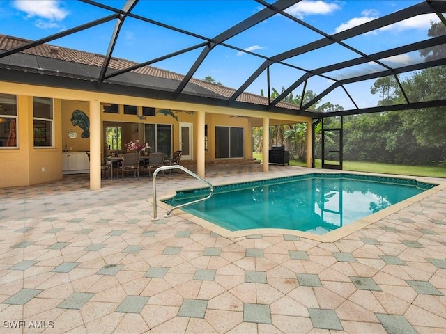 view of pool with a patio area, ceiling fan, and glass enclosure