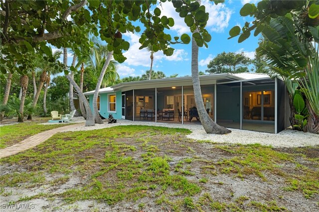 rear view of house featuring a sunroom and a patio