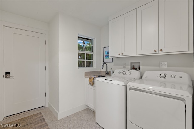 laundry area with sink, washing machine and clothes dryer, and cabinets