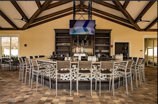 dining area with beamed ceiling and high vaulted ceiling