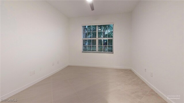 tiled spare room featuring ceiling fan